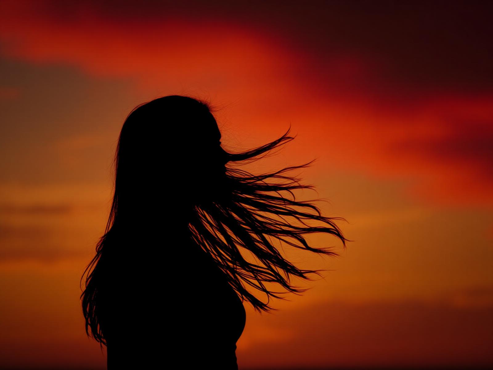 Silhueta de mulher ao pôr do sol